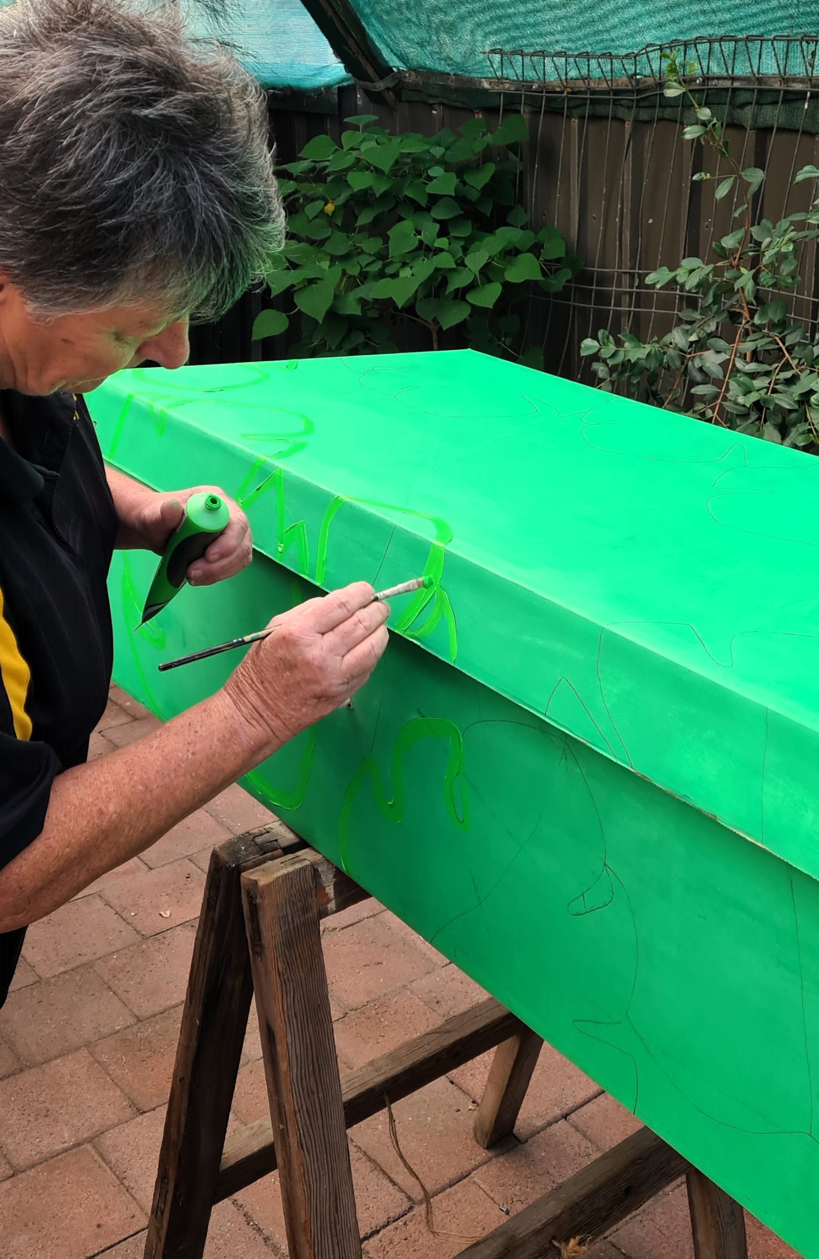 eco coffin decorating - painting leaves as a meaningful symbol for the artist