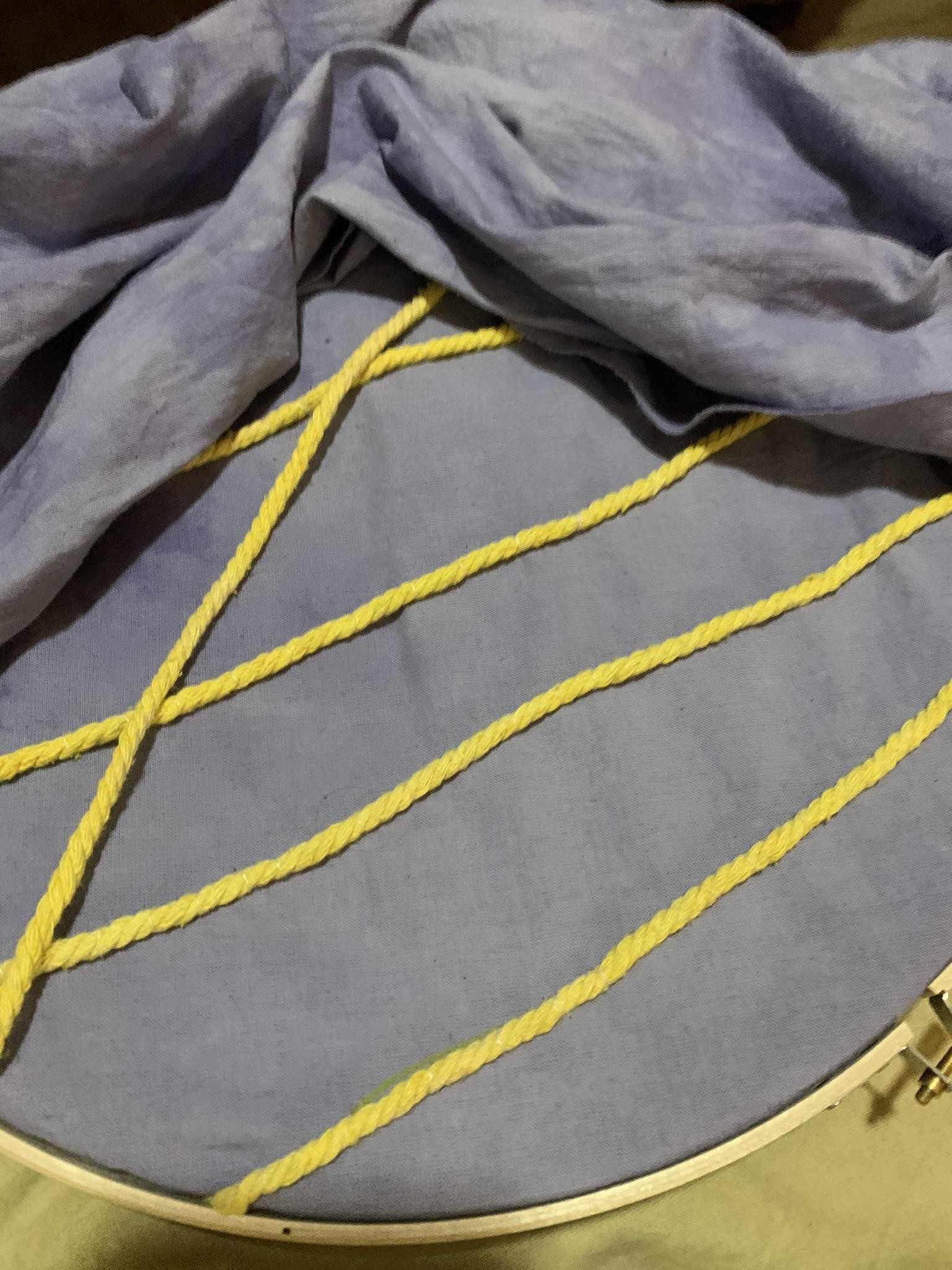 Recycled rope dyed yellow with turmeric and repurposed to create the outline of the artist's fingerprint on her shroud