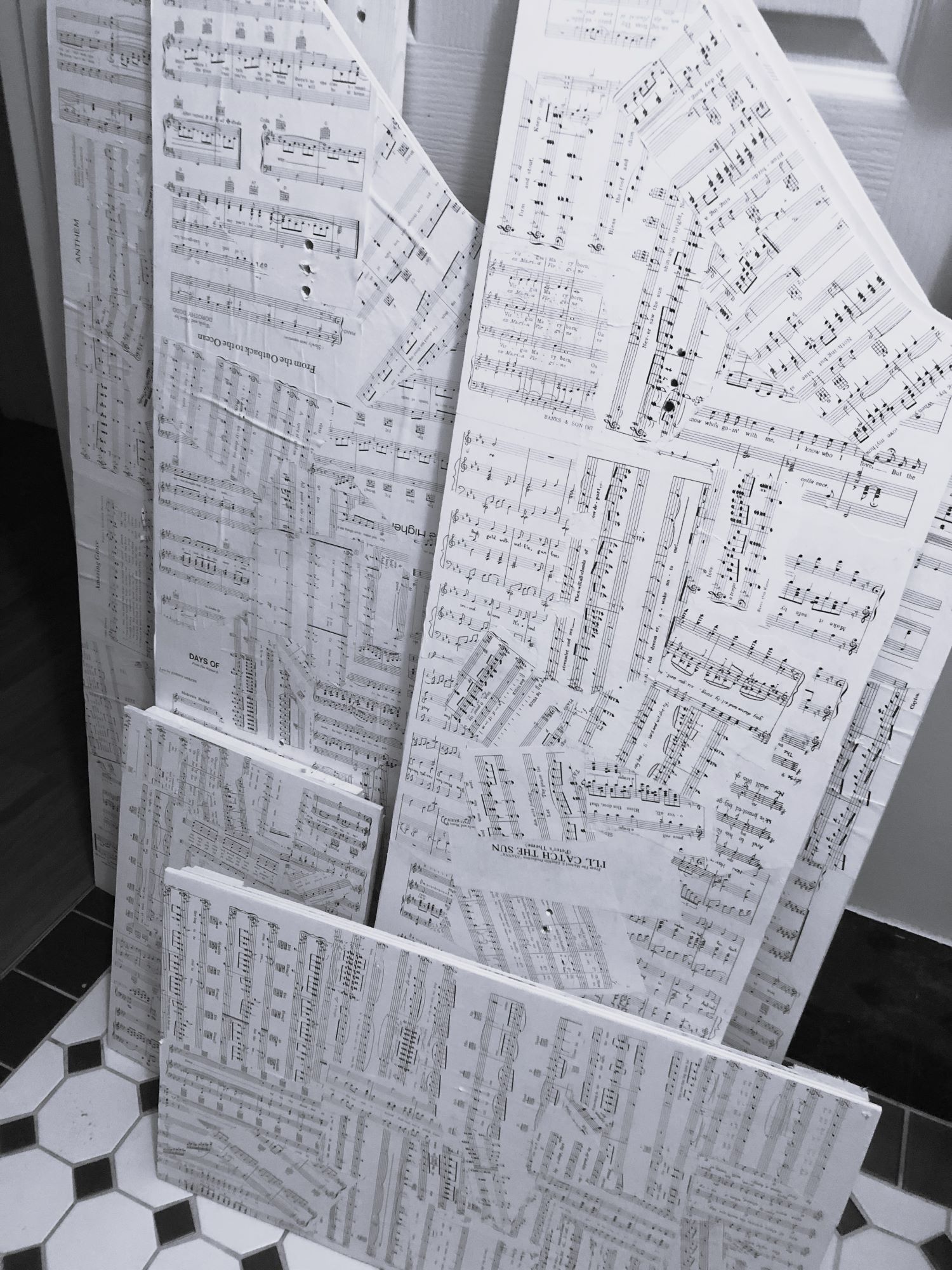 Flat-pack eco-coffin pieces decoupaged with vintage music sheets