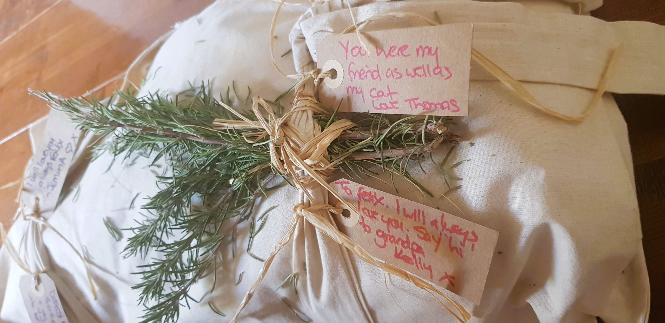 Pet shroud made from calico with brown paper tags with love notes and fresh rosemary